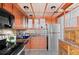 Cozy kitchen with wood cabinets, stone backsplash, stainless refrigerator, and black appliances at 700 N Washington St # 502, Denver, CO 80203