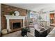 Bright living room with a brick fireplace, balcony access, and a modern chandelier at 700 N Washington St # 502, Denver, CO 80203