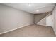 Finished basement rec room with neutral walls and carpet and an entrance to the stairs at 8666 E Easter Ave, Centennial, CO 80112