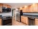 Well-equipped kitchen with stainless steel appliances, wood cabinets, and sleek granite countertops at 8666 E Easter Ave, Centennial, CO 80112