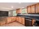 Charming kitchen boasts natural wood cabinetry, granite countertops, and modern stainless steel appliances at 8666 E Easter Ave, Centennial, CO 80112
