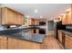 Stylish kitchen featuring wood cabinets, granite countertops, and modern stainless steel appliances at 8666 E Easter Ave, Centennial, CO 80112