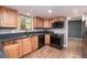 Modern kitchen with light wood cabinets, dark granite countertops and stainless steel appliances at 8666 E Easter Ave, Centennial, CO 80112