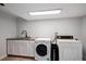 Convenient laundry room features a sink and modern washer and dryer at 8666 E Easter Ave, Centennial, CO 80112