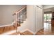 Elegant staircase with wood treads and black iron balusters, adjacent to a hallway at 8666 E Easter Ave, Centennial, CO 80112