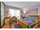 Comfortable bedroom with a bed, desk by the window and a closet with sliding panel doors at 3550 S Harlan St # 174, Denver, CO 80235
