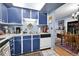Cozy kitchen with blue cabinets, contrasting white countertops, and a view into the dining area at 3550 S Harlan St # 174, Denver, CO 80235