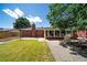 Expansive backyard featuring a brick home, patio, garden and ample space for outdoor activities at 7160 Canosa Ct, Westminster, CO 80030