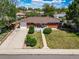 Aerial view of the brick home with a driveway, landscaped front yard, and lush greenery at 7160 Canosa Ct, Westminster, CO 80030