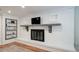 A modern white brick fireplace with a black firebox and a dark wooden mantle with a TV above it at 7160 Canosa Ct, Westminster, CO 80030