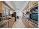 Galley kitchen featuring stainless appliances, tile backsplash, granite counters, and ample wooden cabinetry at 7160 Canosa Ct, Westminster, CO 80030