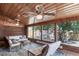 Cozy sunroom featuring brick walls, wood paneling, and serene outdoor views at 7160 Canosa Ct, Westminster, CO 80030