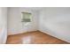 Clean, empty bedroom with wood floors, a bright window, and fresh white paint at 3625 E 128Th Pl, Thornton, CO 80241