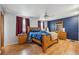Spacious main bedroom with hardwood floors, ceiling fan, and large wood furniture set at 3625 E 128Th Pl, Thornton, CO 80241