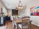 Open-concept dining area with a stylish light fixture and seamless flow to the living room at 9084 Ellis Way, Arvada, CO 80005