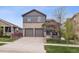Charming two-story home featuring stone accents, a two-car garage, and a well-manicured front yard at 9084 Ellis Way, Arvada, CO 80005