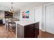 Open kitchen featuring a center island with storage, dark cabinets, and a view into the dining area at 9084 Ellis Way, Arvada, CO 80005