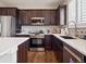 Well-equipped kitchen with dark cabinets, stainless steel appliances, and modern backsplash at 9084 Ellis Way, Arvada, CO 80005