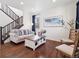 Bright living room with hardwood floors, staircase, stylish furnishings, and a large framed art piece at 9084 Ellis Way, Arvada, CO 80005