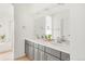 Modern bathroom featuring a dual sink vanity with gray cabinets, a large mirror, and recessed lighting at 5962 S Sheridan Way, Littleton, CO 80123