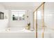 Bright bathroom showcasing a soaking tub, gold-trimmed glass shower, and a window offering natural light at 5962 S Sheridan Way, Littleton, CO 80123