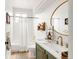 Stylish bathroom with a modern vanity, round mirror, and shower-tub combination at 5962 S Sheridan Way, Littleton, CO 80123