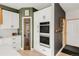 Well-equipped kitchen with stainless steel ovens and white cabinetry complemented by stylish green accent wall at 5962 S Sheridan Way, Littleton, CO 80123