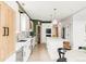Galley kitchen featuring white cabinets, stainless appliances, and wood accents for a modern, airy feel at 5962 S Sheridan Way, Littleton, CO 80123