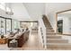 Open-concept living space with hardwood floors, high ceilings, and a modern staircase at 5962 S Sheridan Way, Littleton, CO 80123