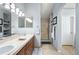Well-lit bathroom with a double sink vanity, a walk-in shower, and modern finishes at 1355 S Ulster St, Denver, CO 80231