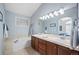 Bright bathroom boasting a soaking tub, double sinks, and modern lighting fixtures at 1355 S Ulster St, Denver, CO 80231