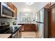 Updated kitchen with stainless steel appliances, modern cooktop, and natural lighting from window at 1355 S Ulster St, Denver, CO 80231