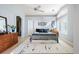 Sunlit bedroom with a ceiling fan, two dressers, and a connecting doorway at 1355 S Ulster St, Denver, CO 80231