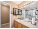 Neat bathroom featuring a vanity with storage, a well-lit mirror, and a glass-enclosed shower at 11620 W 62Nd Pl # 201, Arvada, CO 80004