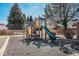 Community playground with a slide, climbing area, and soft rubber ground at 11620 W 62Nd Pl # 201, Arvada, CO 80004