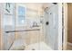 Modern glass-enclosed shower with a built-in bench and shelving, complemented by a window for natural light at 11620 W 62Nd Pl # 201, Arvada, CO 80004