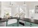 Inviting kitchen featuring green cabinetry, stainless steel appliances, and a farmhouse sink at 539 Baker St, Longmont, CO 80501