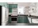 Contemporary kitchen with green cabinets, stainless appliances, and stylish granite countertops at 539 Baker St, Longmont, CO 80501