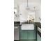 Farmhouse style kitchen featuring a large sink, green cabinets, and views into the living room at 539 Baker St, Longmont, CO 80501