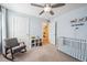 Bright bedroom with a rocking chair, hiking-themed decorations, and a white crib with blue lining at 1107 Sunrise Dr, Brighton, CO 80603