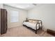 Bedroom with white walls, carpeted floors, a black futon bed and a window for natural light at 1107 Sunrise Dr, Brighton, CO 80603