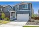 Charming two-story home with a well-maintained lawn and a two-car garage on a sunny day at 1107 Sunrise Dr, Brighton, CO 80603