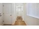 Bright hallway with wood floors leading to the front door and featuring white walls at 1107 Sunrise Dr, Brighton, CO 80603