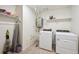 Bright laundry room with modern washer and dryer, storage shelves, and tile floors at 1107 Sunrise Dr, Brighton, CO 80603