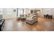 Open-concept living room with wood floors, neutral sectional sofa, and view of the kitchen at 1107 Sunrise Dr, Brighton, CO 80603