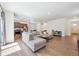 Open-concept living room with wood floors, neutral sectional sofa, and view of the kitchen at 1107 Sunrise Dr, Brighton, CO 80603