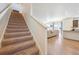 Carpeted stairs lead to the main living area and showcase the modern design of the home at 1107 Sunrise Dr, Brighton, CO 80603