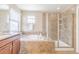 Bathroom featuring a soaking tub and a separate tiled walk-in shower with a glass door at 404 Dusk Ct, Erie, CO 80516
