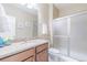 Bathroom featuring granite countertops, wood cabinets, and a shower with sliding glass doors at 404 Dusk Ct, Erie, CO 80516
