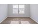Well-lit bedroom with plush carpeting, base trim and plenty of natural light from a large window at 404 Dusk Ct, Erie, CO 80516